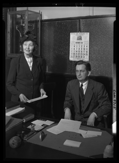 Georgetown College; Belle of the Blue; interior; office; man and                             woman standing next to a desk