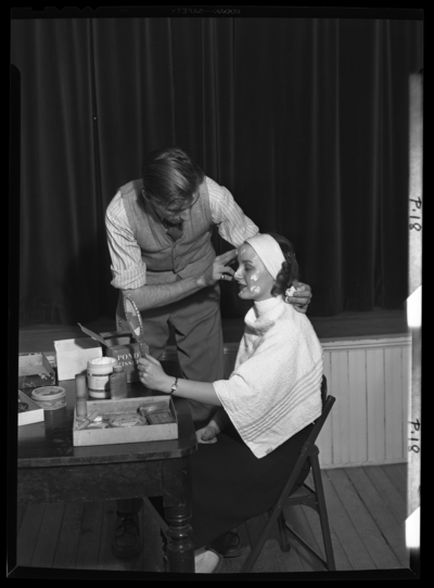 Georgetown College; Maskrafters makeup; interior; man applying                             makeup to woman's face