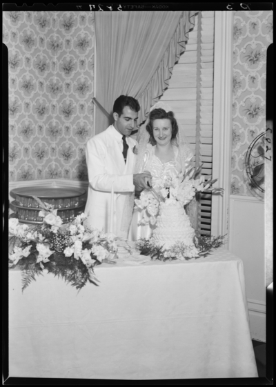 Lucille Brown; wedding; bride and groom cutting wedding                             cake