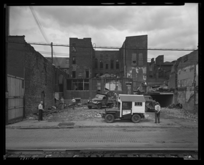 Woolworth; View of West Main; lot under construction (building                             torn down); Nina Electric Company jeep parked in front of construction                             site