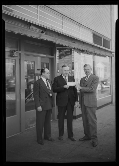 Kroger Store, 726 East Main; presentation of car; exterior; group                             of three men standing in front of store