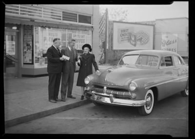 Kroger Store, 726 East Main; presentation of car; exterior; two                             men and a woman standing next to a car