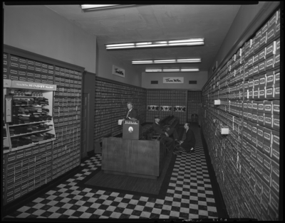 Thom McAn Shoe Company, 114 West Main; interior; man being waited                             on