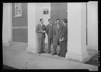 Belle of the Blue; Georgetown College; exterior; group of men                             standing next to building entranceway