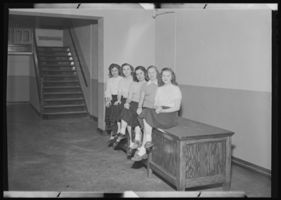Belle of the Blue; Georgetown College; interior; group of women                             sitting on desktop