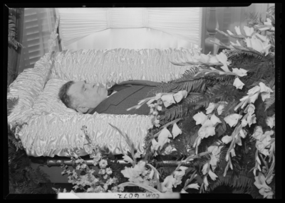 H. T. Wagner; corpse; open casket surrounded by                             flowers