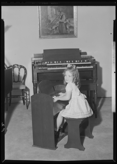 Shackleton’s Music Store Incorporated, 147 East Main; interior;                             young girl sitting at a child's piano