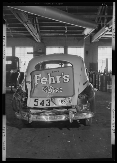 Lexington Yellow Cab, 150 North Limestone; interior; wrecked                             (damaged) cab (car); rear view; advertisement for Fehr's Beer on                             truck of cab