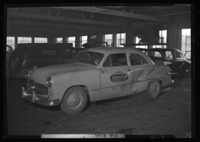 Lexington Yellow Cab, 150 North Limestone; interior; service                             garage; wrecked (damage) cab, drivers side view; Lafayette Studios truck                             in background