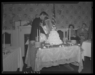 Mr. & Mrs. Ronald Lee Cole; wedding; interior; bride and                             groom kissing in front of wedding cake