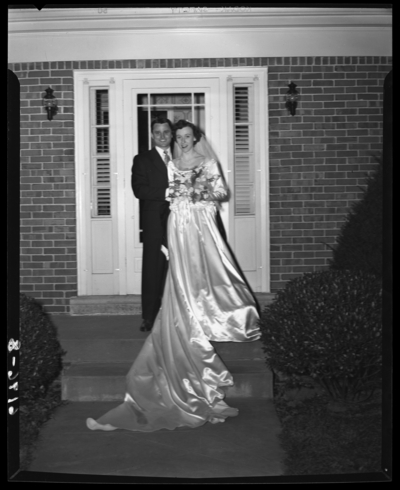 Fisher-Farris wedding; exterior; bride and groom standing in                             front of doorway
