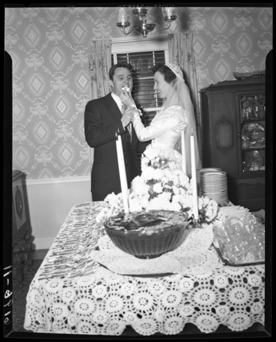 Fisher-Farris wedding; interior; bride feeding groom                             cake