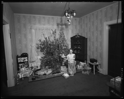 Gross, Judy; Christmas tree; child in front of tree; interior of                             house