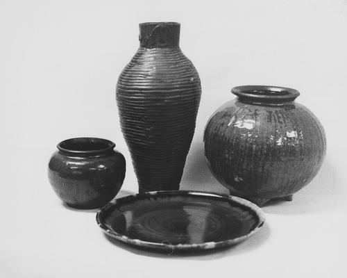 Three ceramic pots and a platter by John Tuska. One of the pots is a coil pot, the other two appear to be thrown on a potter's wheel
