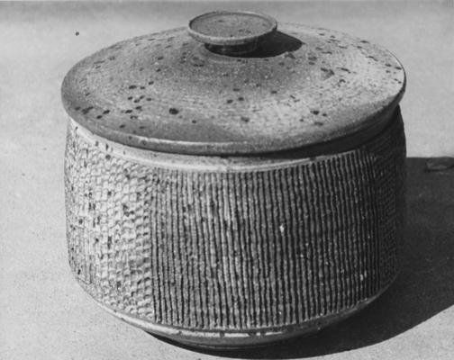 A ceramic covered jar with various designs by John Tuska