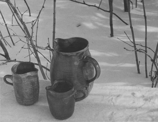 Three ceramic pitchers sitting in snow, pieces of John Tuska's Alfred University graduate work