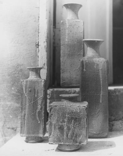 Four ceramic square shaped vases on concrete steps by John Tuska
