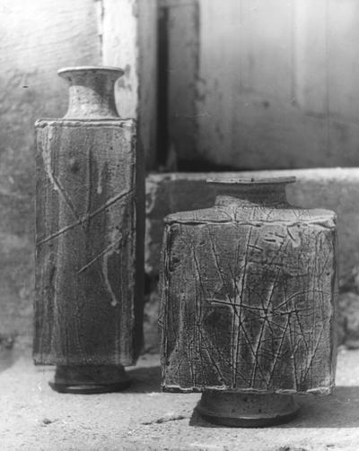 Two ceramic square shaped vases on concrete steps by John Tuska