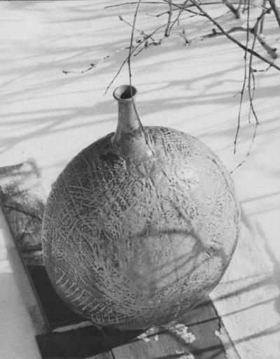 A ceramic pot sitting in snow, pieces of John Tuska's Alfred University graduate work