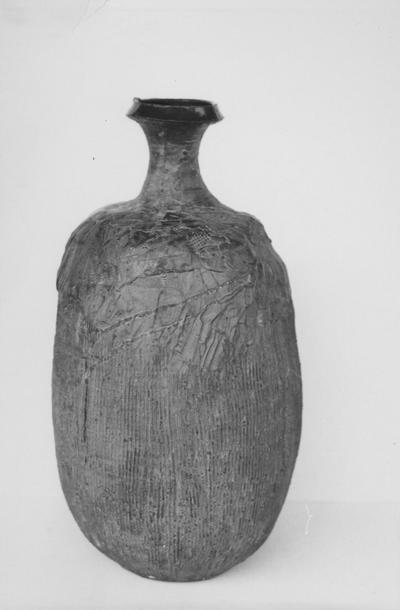A ceramic vase with vertical lines by John Tuska