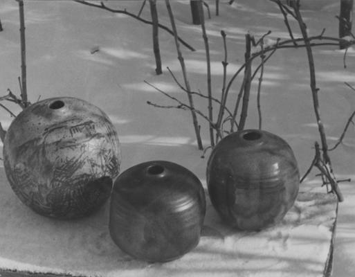 Three ceramic pots sitting in the snow, pieces of John Tuska's Alfred University graduate work