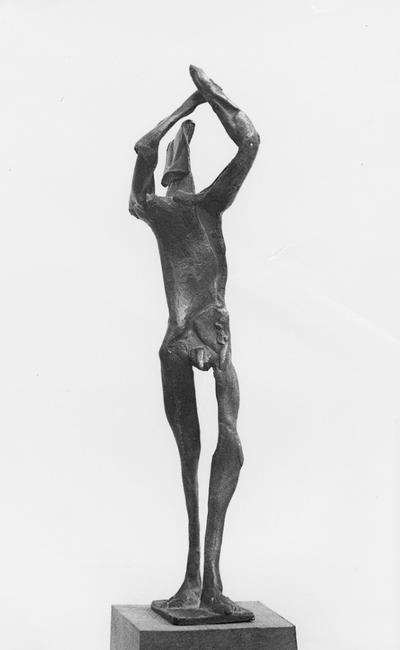 A bronze sculpture of a male nude with a walnut base entitled 