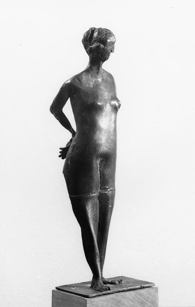 A bronze sculpture of a female nude with a cherry base entitled 