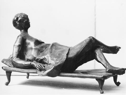 A bronze sculpture of a female figure entitled 