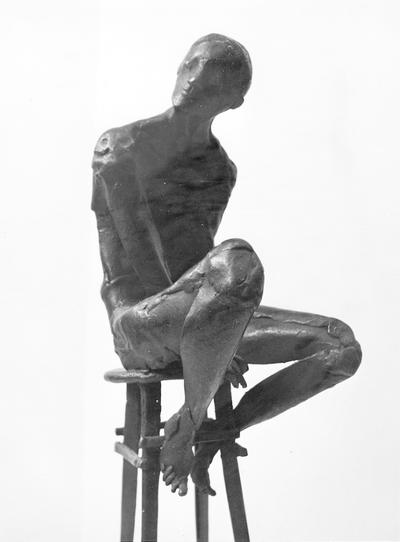 A bronze sculpture of a male nude on a high chair by John Tuska. This sculpture is one of the Italy inspired bronzes created during and after Tuska's trip to Italy in 1969