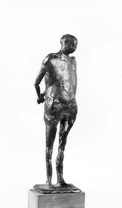 A bronze sculpture of a male nude with a walnut base entitled 