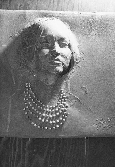 A ceramic tile relief of a woman with beads by John Tuska