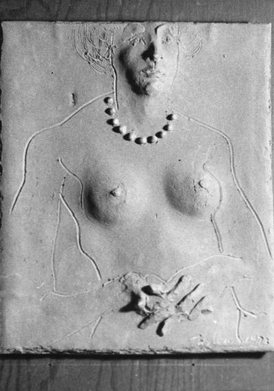 A ceramic tile relief of a female nude with beads and hands folded by John Tuska