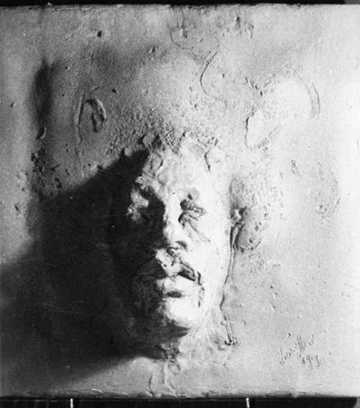 A ceramic tile relief of a male head entitled 