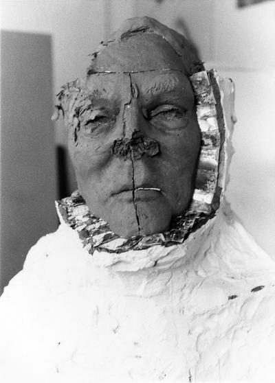 An image of plaster being removed from a John Sherman Cooper bust by John Tuska