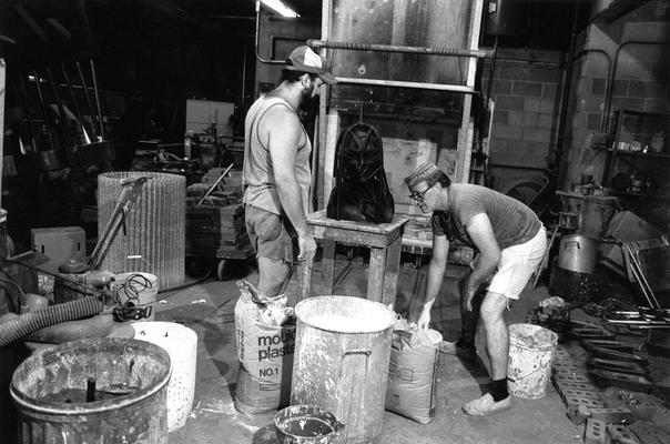 John Tuska and Jack Gron applying plaster to a wax mold of the John Sherman Cooper bust