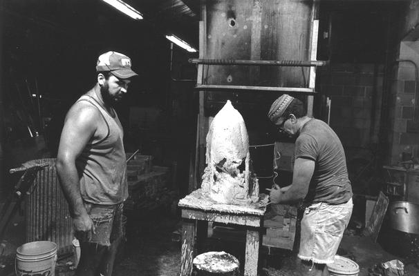 John Tuska and Jack Gron applying plaster to a wax mold of the John Sherman Cooper bust