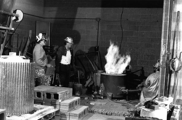 John Tuska, an unidentified man and Jack Gron heating bronze for the John Sherman Cooper bust in the University of Kentucky foundry