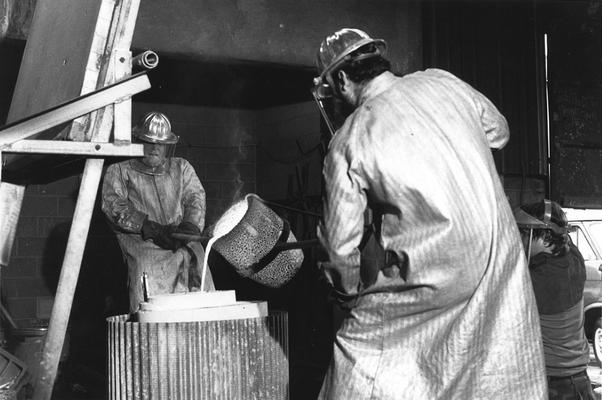 An unidentified man and Jack Gron pouring bronze in the mold for the John Sherman Cooper bust