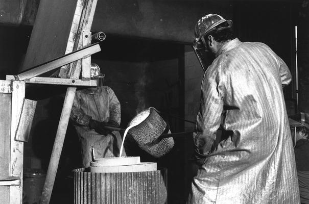 An unidentified man and Jack Gron pouring bronze in the mold for the John Sherman Cooper bust