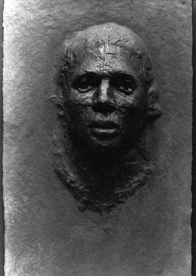 A cast paper and graphite sculpture of a head by John Tuska