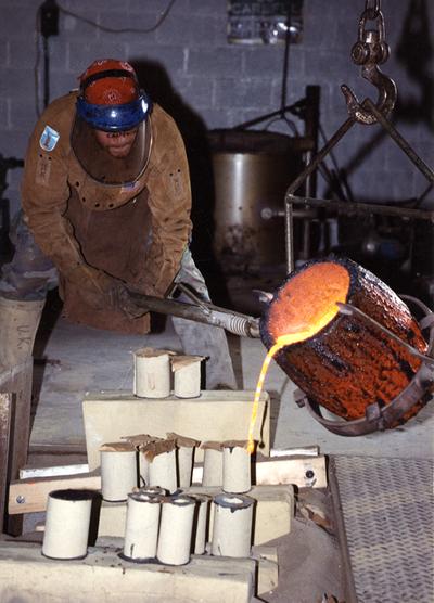 Scott Oberlink pouring bronze from a crucible in the University of Kentucky foundry for the casting 