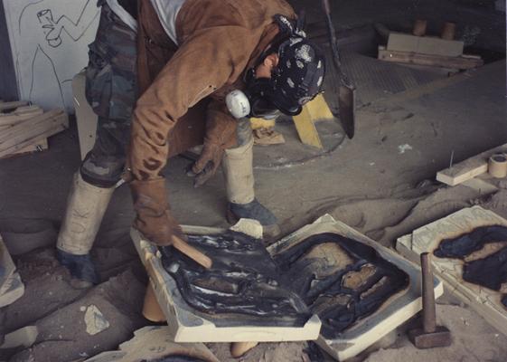 Scott Oberlink breaking apart a sand mold in the University of Kentucky foundry during the casting 