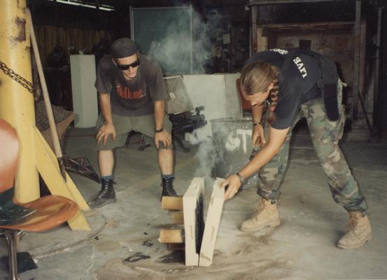 Andrew Marsh and Scott Oberlink opening a sand mold after having bronze poured in the University of Kentucky foundry for the casting of 
