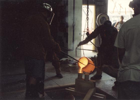 Jack Gron, Scott Oberlink, an unknown woman and man pouring bronze in the University of Kentucky foundry for the casting of 