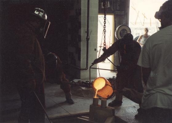 Jack Gron, an unidentified man, Scott Oberlink, an unknown woman and man pouring bronze in the University of Kentucky foundry for the casting of 