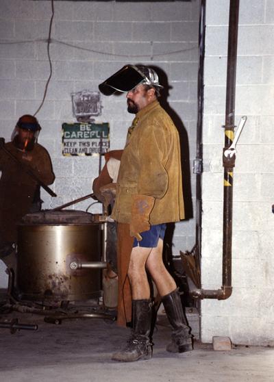 An unknown man, Scott Oberlink and Jack Gron at the University of Kentucky foundry during the casting of 