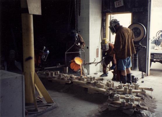 An unidentified man, Scott Oberlink, Andrew Marsh and Jack Gron pouring bronze at the University of Kentucky foundry for the casting of 