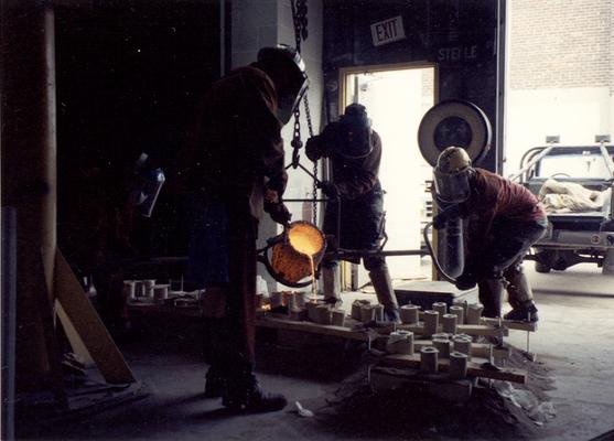 An unidentified man, Jack Gron, Scott Oberlink and Andrew Marsh pouring bronze at the University of Kentucky foundry for the casting of 