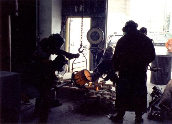 Scott Oberlink, an unidentified man, Andrew Marsh and Jack Gron pouring bronze at the University of Kentucky foundry for the casting of 