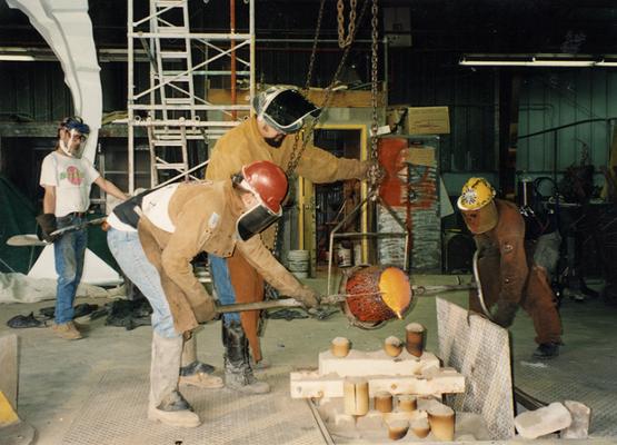 An unidentified man, Scott Oberlink, Jack Gron and Andrew Marsh pouring bronze at the University of Kentucky foundry for the casting of 